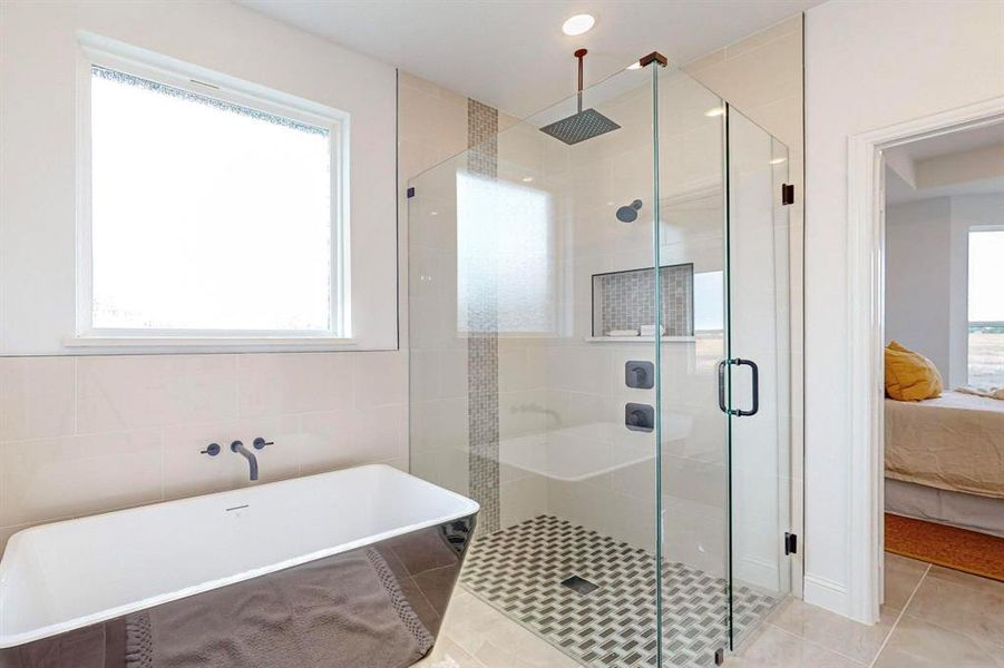 Bathroom with independent shower and bath, tile patterned flooring, a healthy amount of sunlight, and tile walls