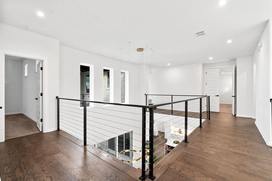 upstairs catwalk looks down on the primary living space and features custom hand rails