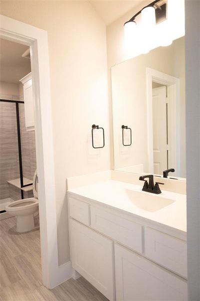 Bathroom with vanity, walk in shower, and toilet