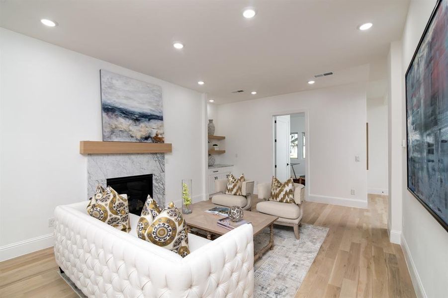 Living room featuring a premium fireplace and light hardwood / wood-style flooring