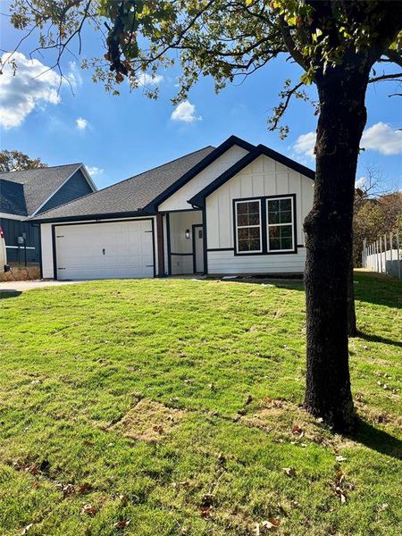 Ranch-style house featuring a front lawn and a garage