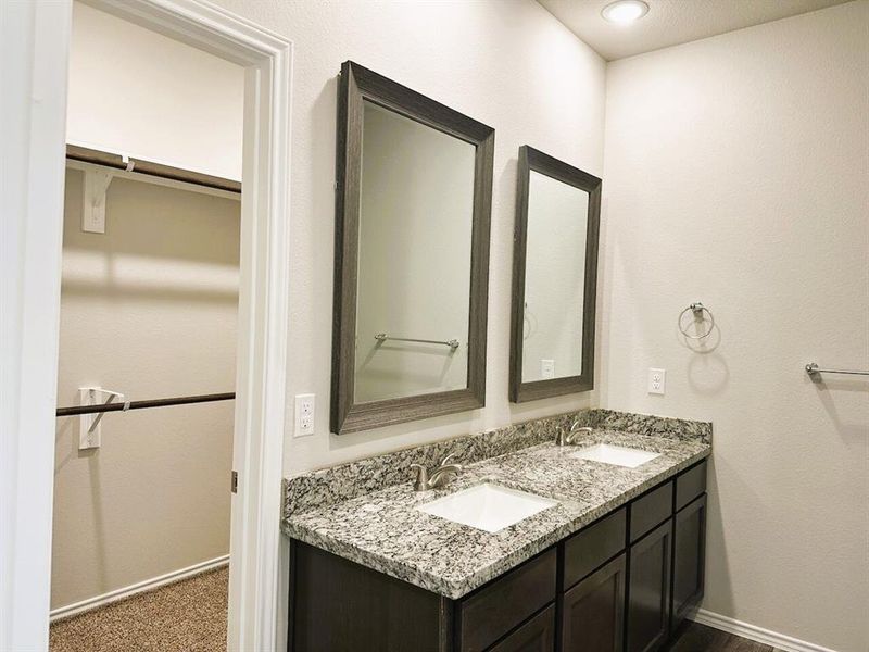 Double sinks, granite counters, framed mirrors- this master bath has it all!