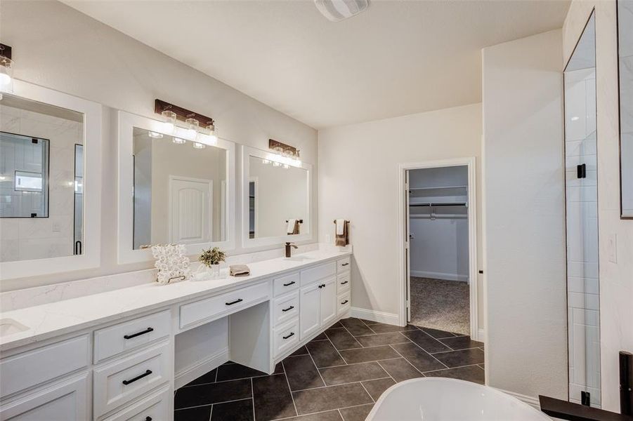 Bathroom with a washtub, dual vanity, and tile patterned floors