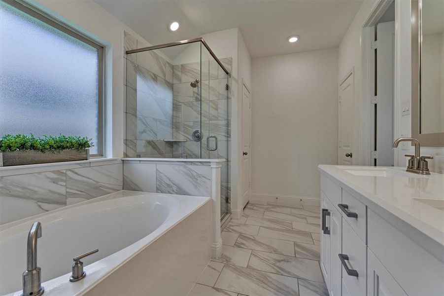 Primary bathroom features dual sinks, garden tub and separate shower plus walk in closet