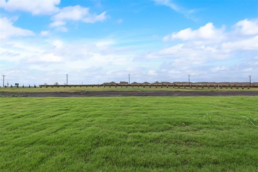 View of property's community featuring a rural view and a yard