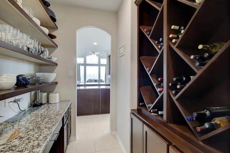 Spacious and elegant wine room with  extra cabinets and a desk to use it with a computer or buffet for entertaining.