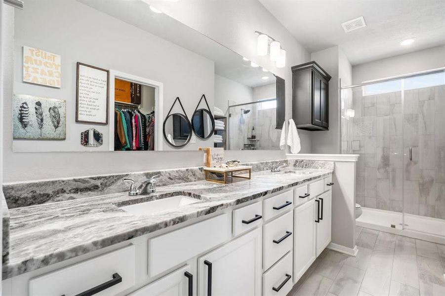 Luxury primary bath with granite countertops, double sinks and large walk-in shower!  Look at all the storage!