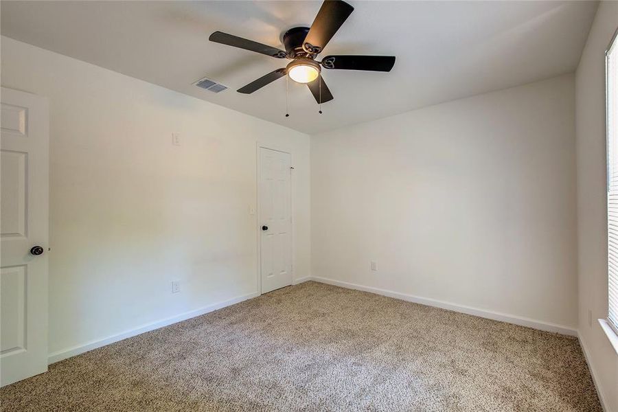 Carpeted third room featuring ceiling fan