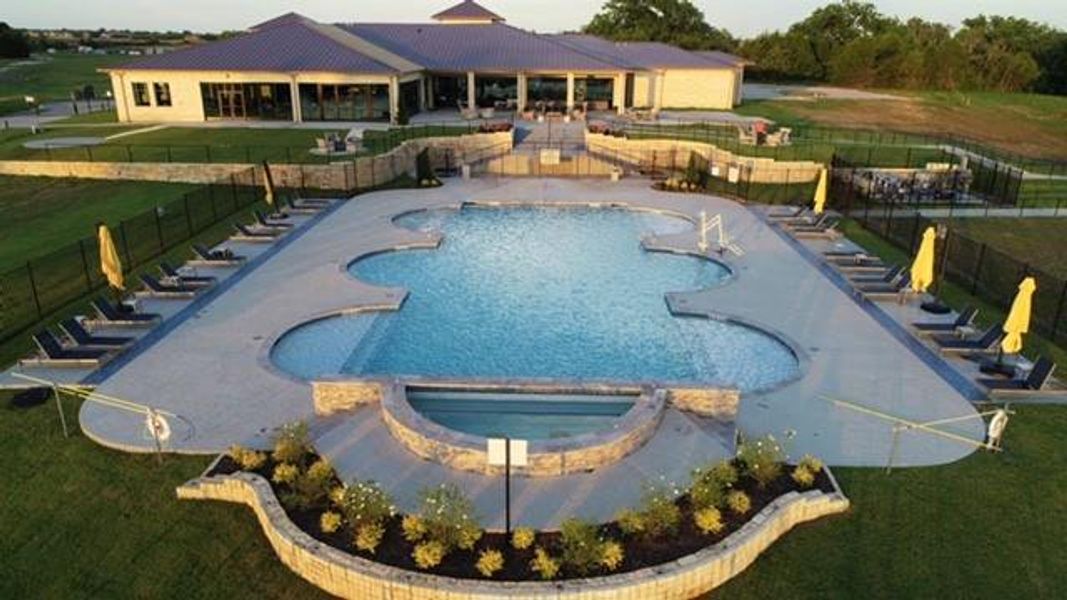 View of swimming pool featuring a hot tub, a patio area, and a yard