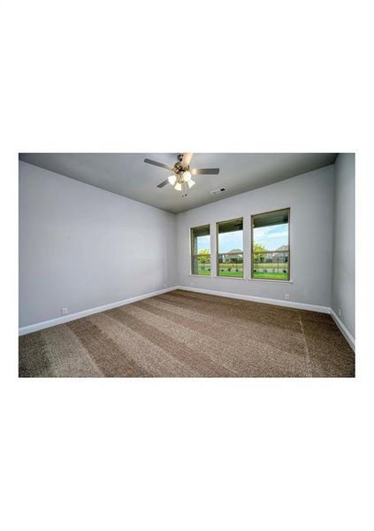 Empty room featuring ceiling fan and carpet floors