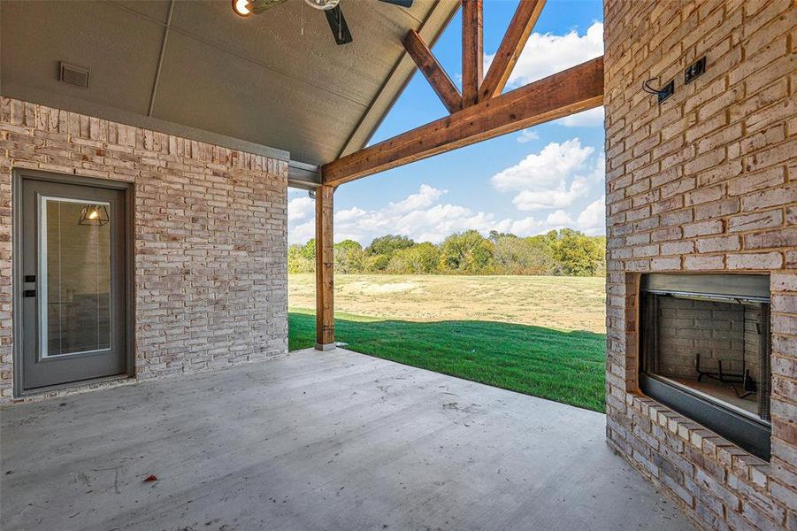 View of patio / terrace with exterior fireplace and ceiling fan