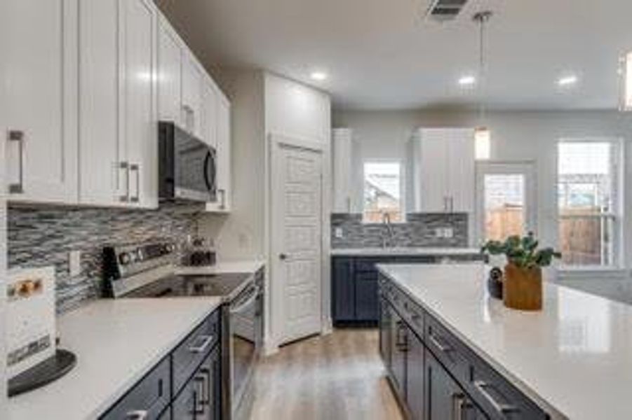 Kitchen with light hardwood / wood-style flooring, stainless steel appliances, a wealth of natural light, and white cabinets