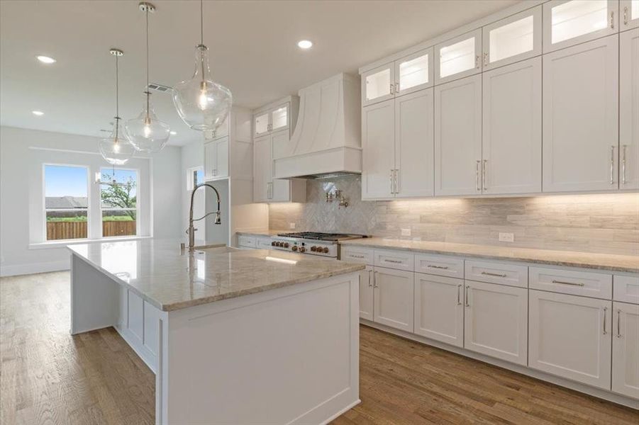 Kitchen featuring white cabinetry, light hardwood / wood-style floors, and custom exhaust hood