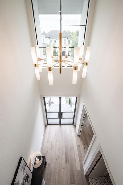 The iron entry doors and a dramatic double-height foyer introduce the 4,788-square-foot elevator-ready home with soaring ceilings, wide-plank oak floors, oversized aluminum windowsand elegant lighting.