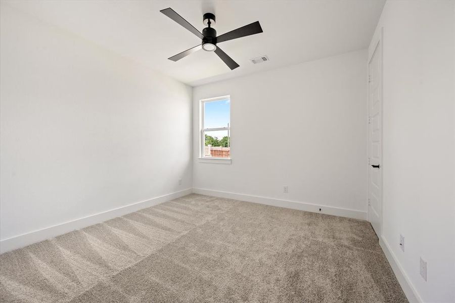 Carpeted spare room featuring ceiling fan