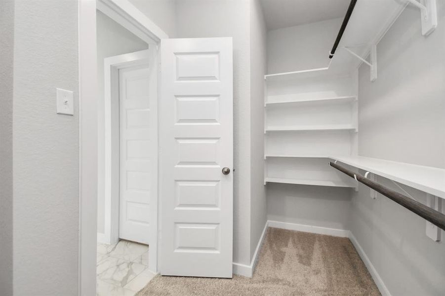 This generously sized closet features built-in shelving, offering abundant room for impeccable organization. Sample photo of completed home with similar floor plan. Actual colors and selections may vary.