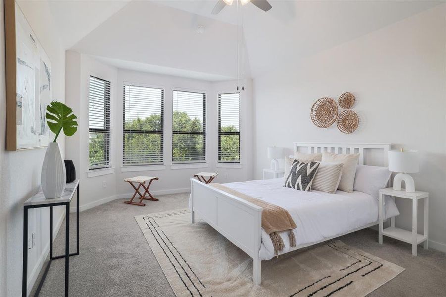 The master bedroom with its wall of windows and hill country views.