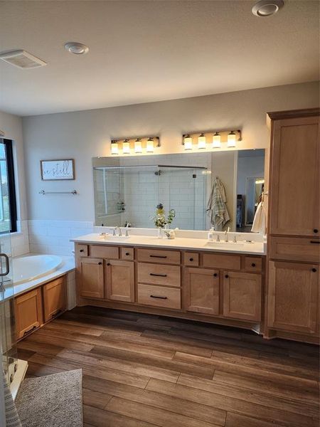 Bathroom with vanity, plus walk in shower, and hardwood / wood-style flooring