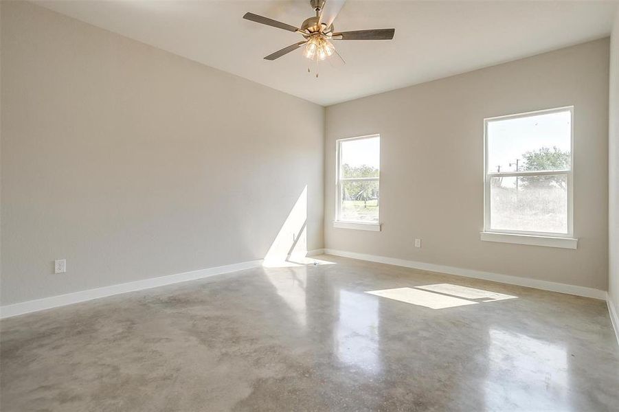 Empty room featuring ceiling fan and concrete floors