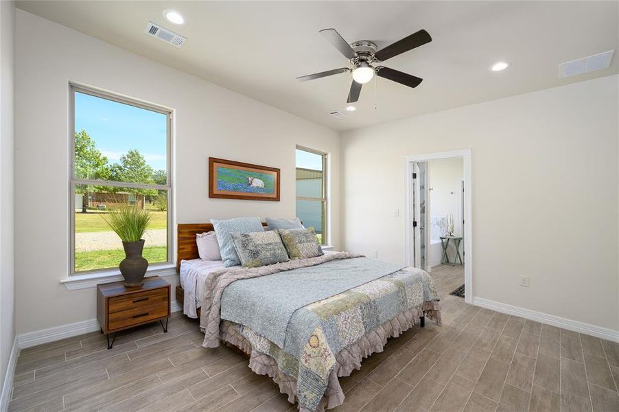 Bedroom featuring multiple windows, light wood-type flooring, and ceiling fan