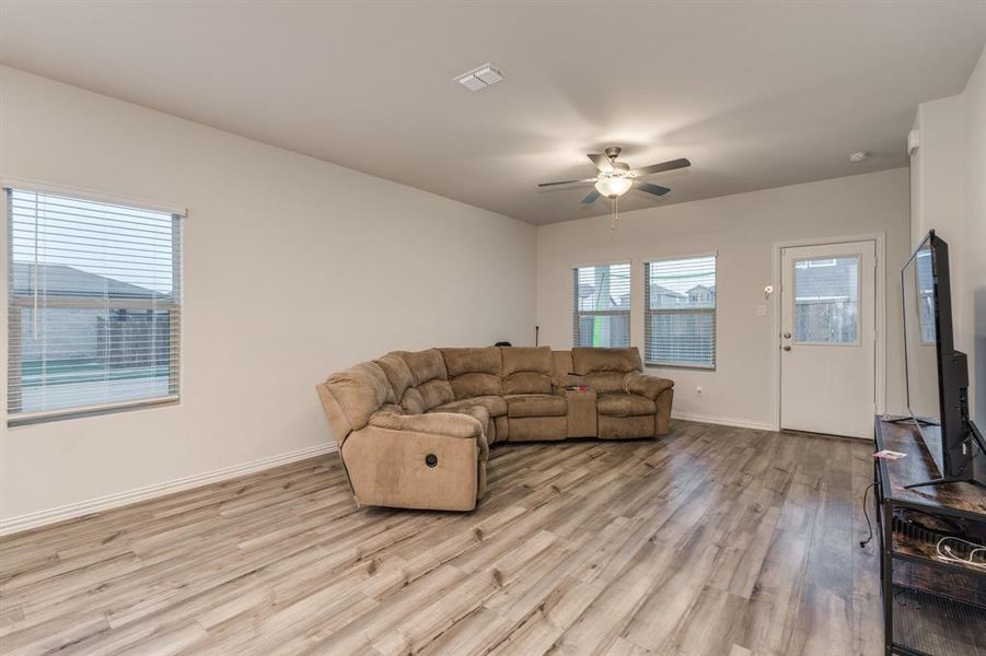 Living room with ceiling fan and light hardwood / wood-style floors