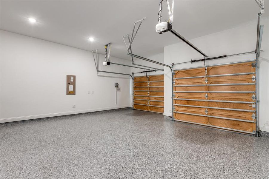 Garage featuring a garage door opener and epoxy floor.