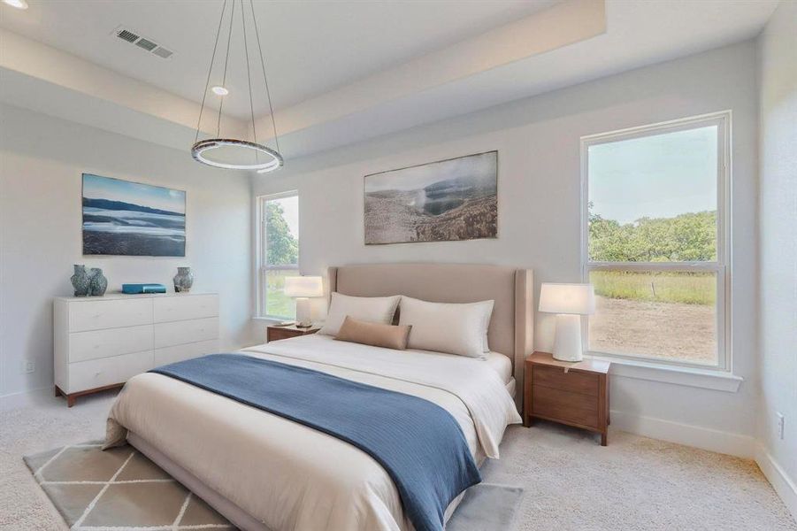 Staged Main Bedroom Carpeted bedroom featuring a raised ceiling