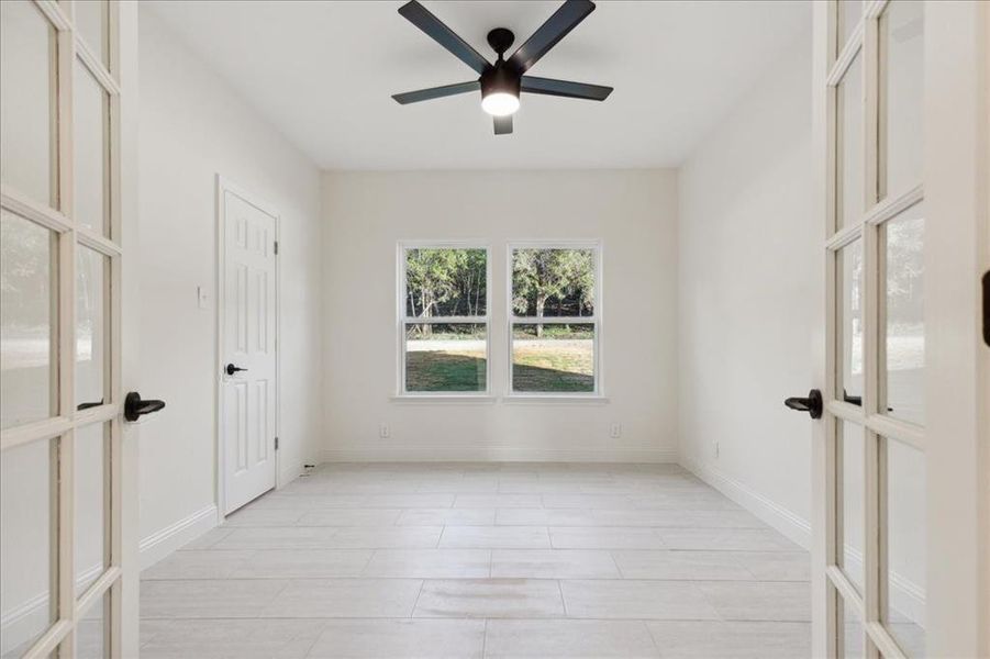 Spare room featuring french doors, ceiling fan, and light tile floors