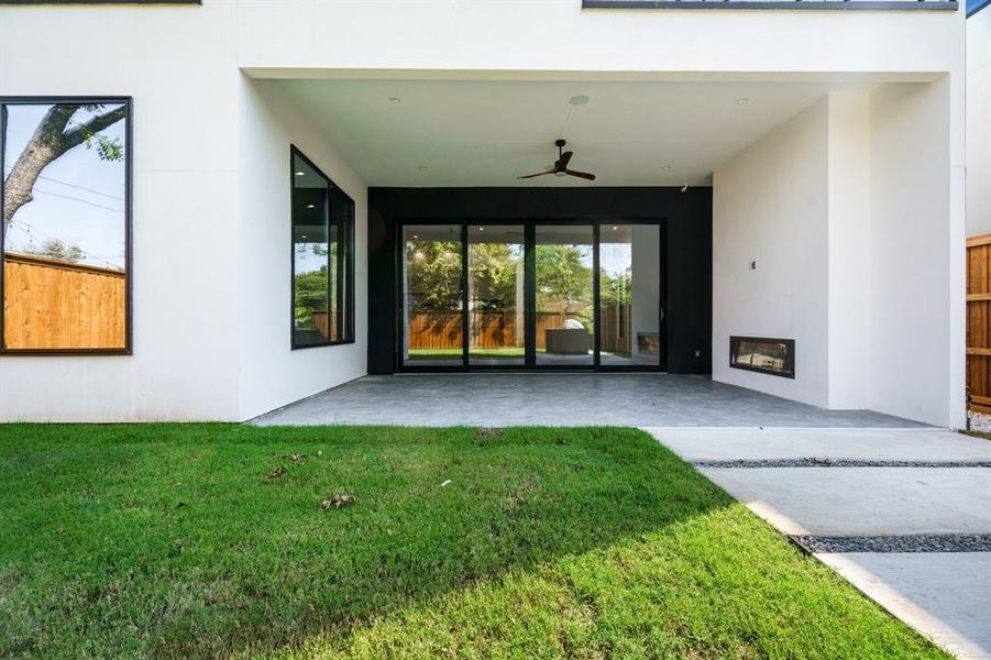 View of exterior entry featuring a yard, a patio area, and ceiling fan