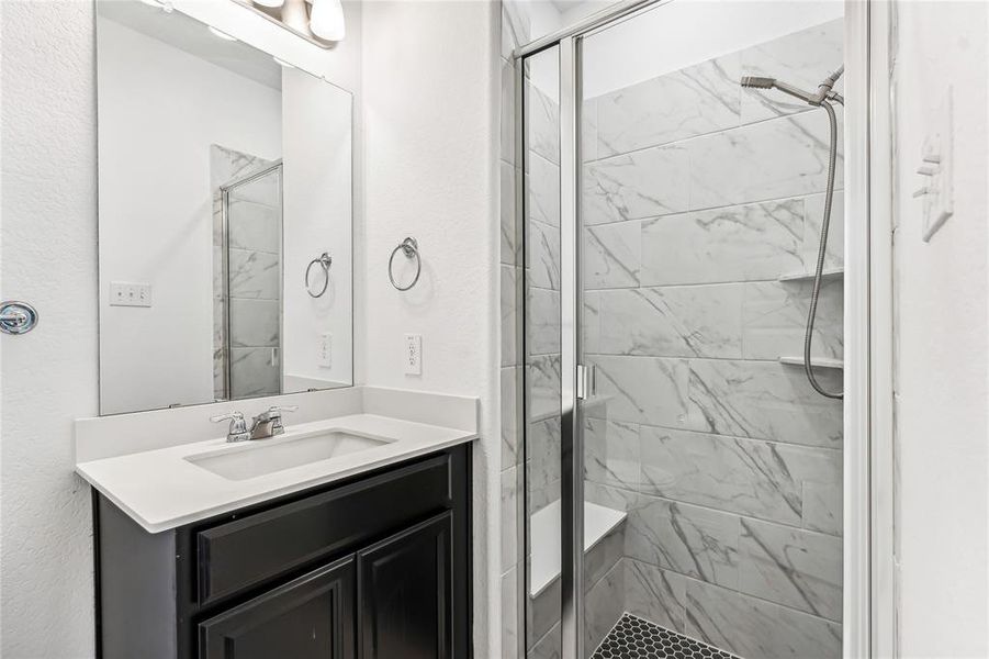 Bathroom with vanity and a shower with shower door