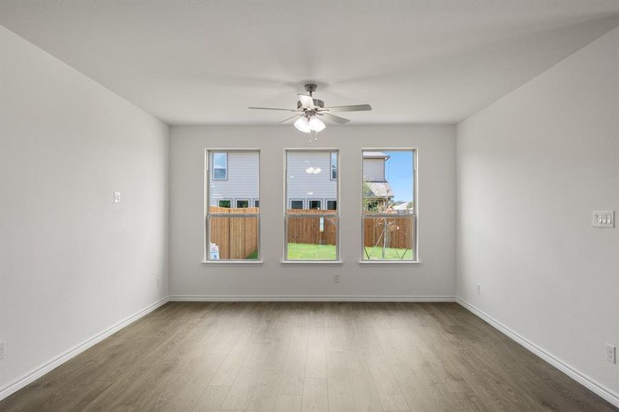 Spare room featuring dark wood-type flooring and ceiling fan