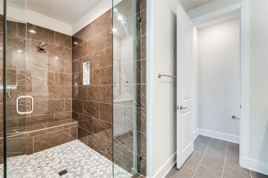 Bathroom featuring tile patterned floors and a shower with shower door