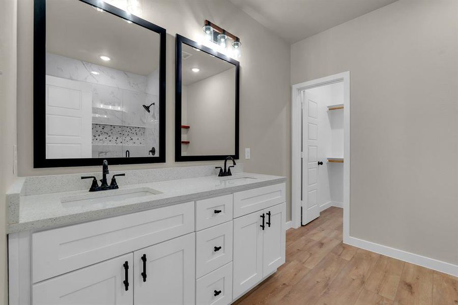 Bathroom featuring hardwood / wood-style floors, walk in shower, and vanity