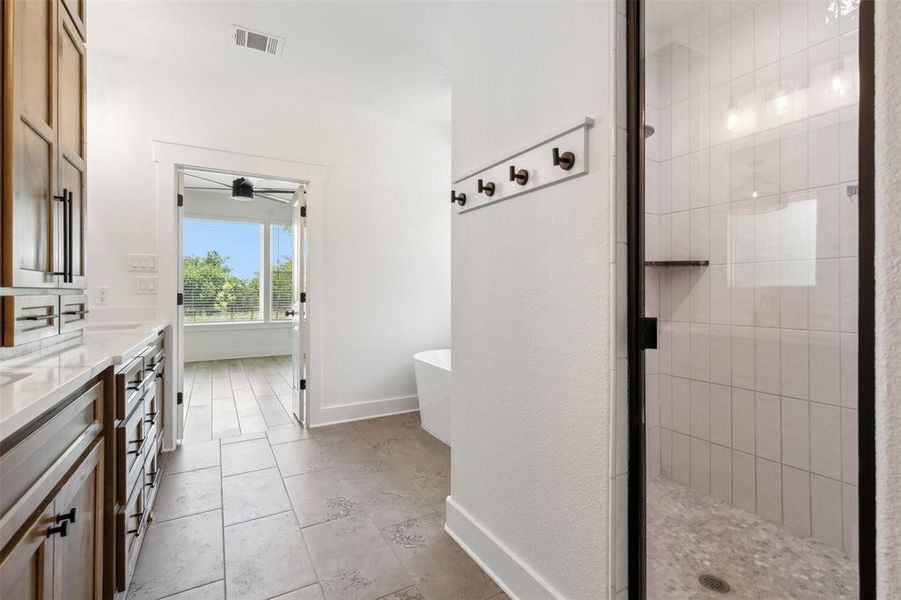 Bathroom featuring separate shower and tub, vanity, and tile floors