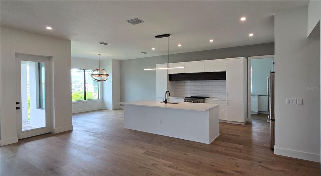 Open Kitchen with Breakfast Bar and Dining Area.  The Laundry Room is  beyond the Kitchen.