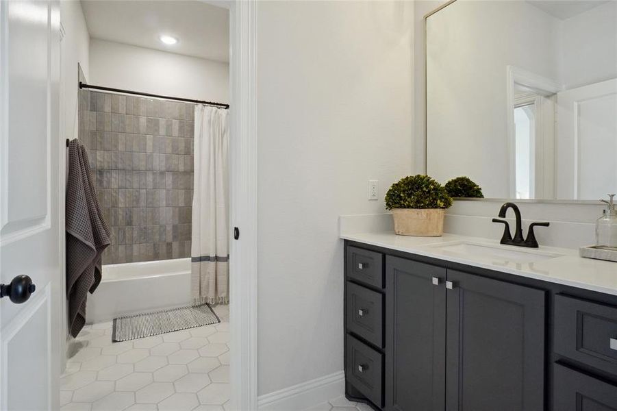 Bathroom with vanity, tile patterned floors, and shower / bath combination with curtain