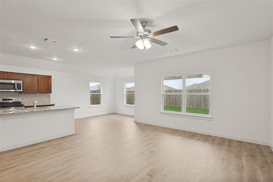 Unfurnished living room featuring light hardwood / wood-style floors, plenty of natural light, and ceiling fan