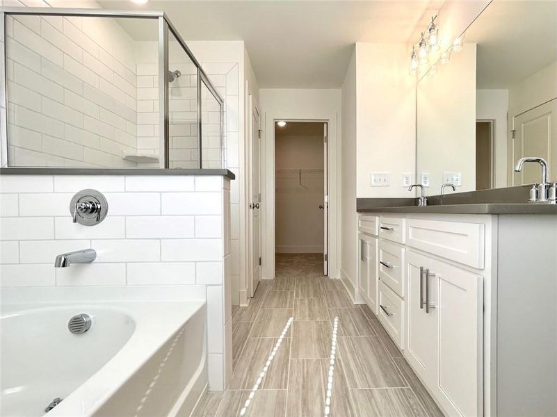 Bathroom featuring tile flooring, tiled shower, and vanity