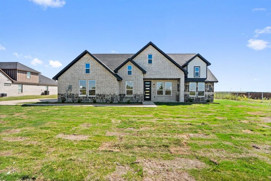 Rear view of house with a lawn and central AC unit