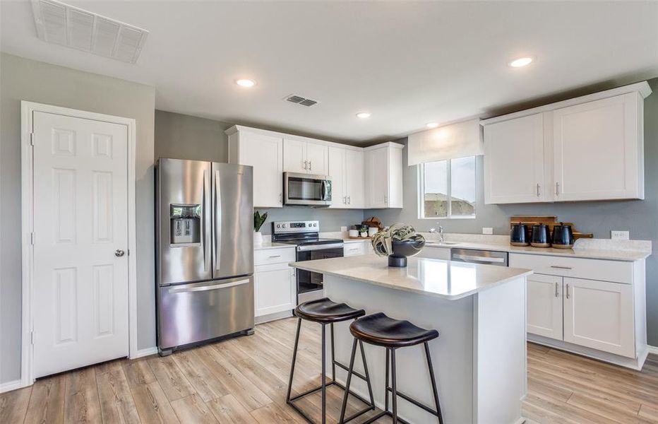 Bright kitchen with an expansive center island perfect for gatherings*Photos of furnished model. Not actual home. Representative of floor plan. Some options and features may vary.