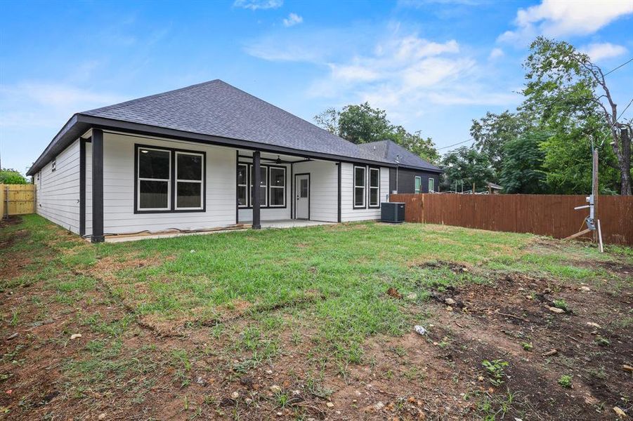 Back of property with a lawn and cooling unit