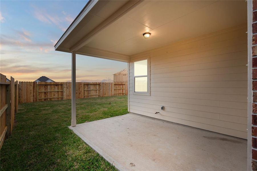The covered patio is generously sized, providing ample space for various outdoor activities.