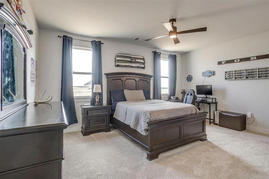 Carpeted bedroom featuring ceiling fan