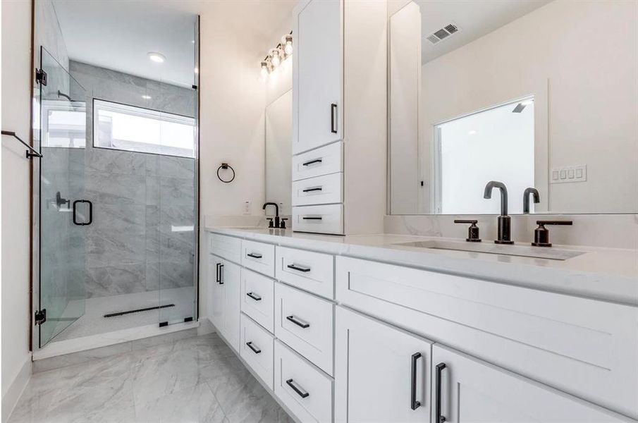 Bathroom with a shower with shower door and vanity