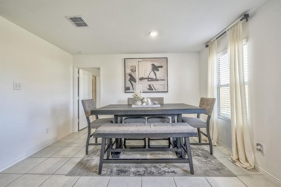 Dining space with light tile patterned flooring