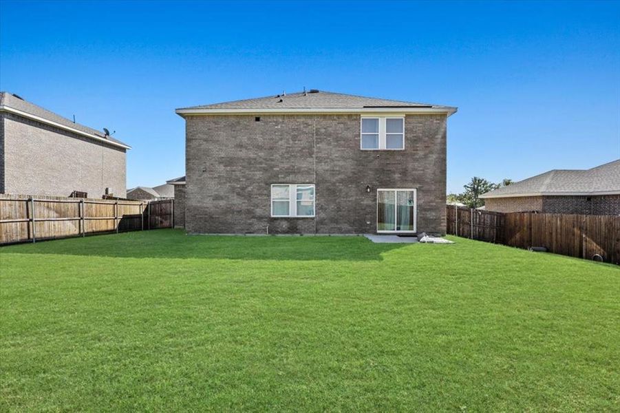 Rear view of property with a lawn