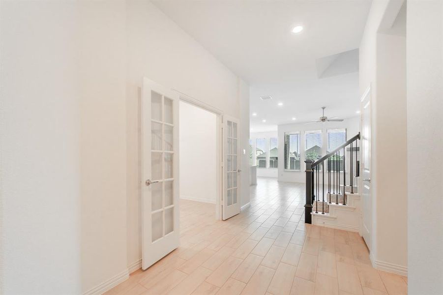 Hall with light hardwood / wood-style flooring and french doors