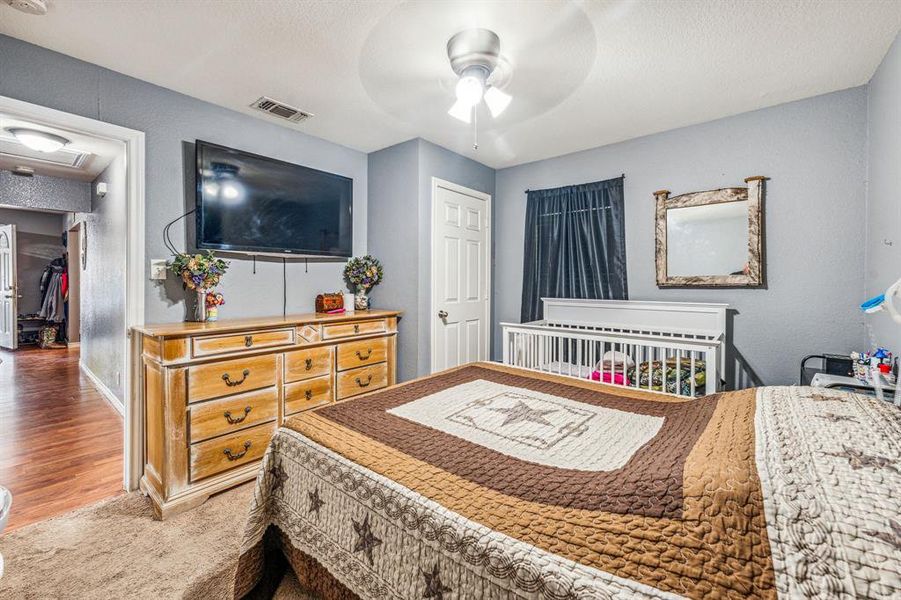 Bedroom featuring ceiling fan, wood-type flooring, and a closet