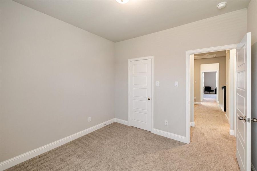 Unfurnished bedroom featuring light carpet and a closet