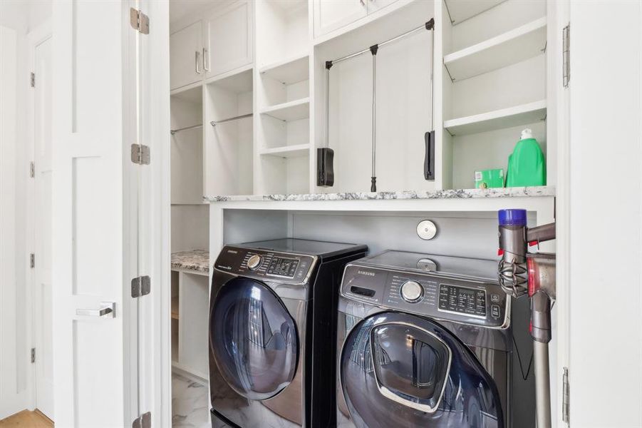 The laundry room is efficient and offers ample built-ins and hanging spaces.